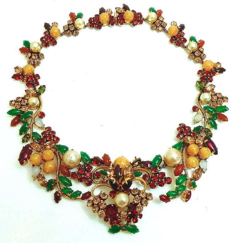 This is an incredibly rare Christian Dior Germany necklace dated 1962 and features faux pearls with red, green, blue, and topaz rhinestone accents in a gold-tone setting. This fabulous piece measures 17” and has a rear pressure closure. In mint