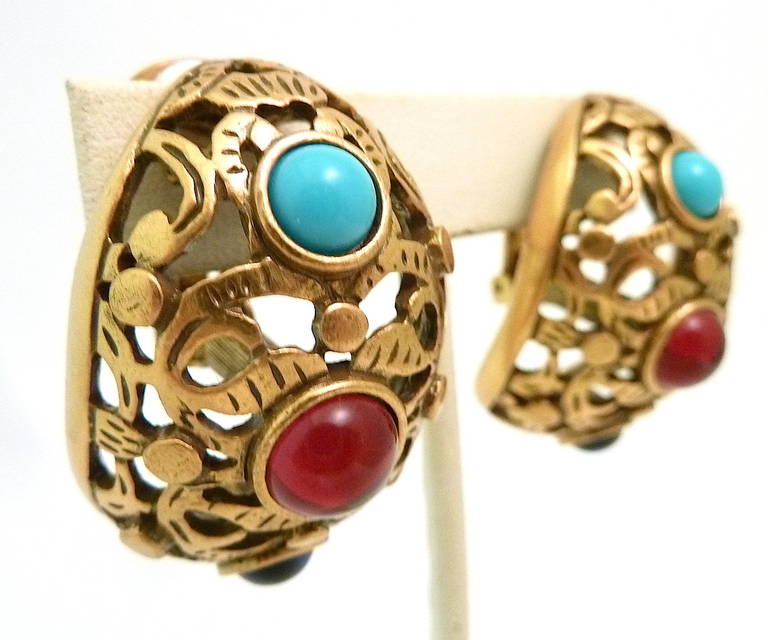 These vintage signed Oscar de la Renta earrings feature red, blue and turquoise rhinestones in a gold-tone setting. In excellent condition, these clip earrings measure 1 ½” x 1” and are signed Oscar de la Renta.
