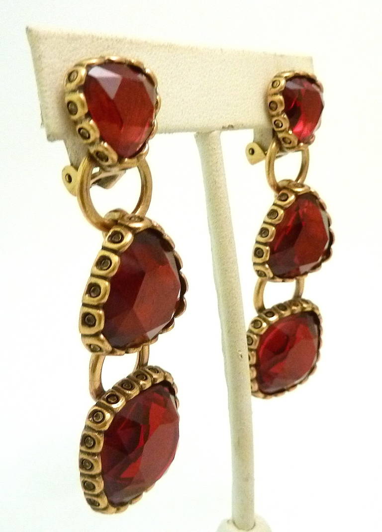These vintage couture runway signed Oscar de la Renta earrings feature bezel cut red poured glass in a gold-tone setting. In excellent condition, these earrings measure 2 5/8” x ¾” and is signed Oscar de la Renta.