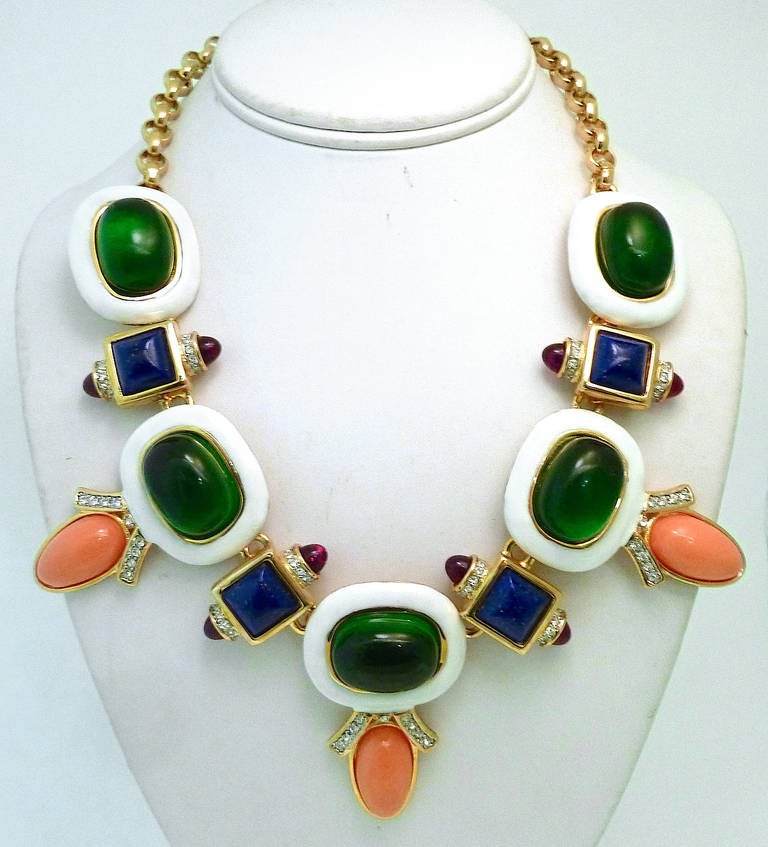 This Kenneth J. Lane necklace features green, blue and faux coral stones with clear crystal accents on white enameling in a gold-tone setting.  It is a show stopper and we did find a bracelet a few weeks ago.    It’s in excellent condition and