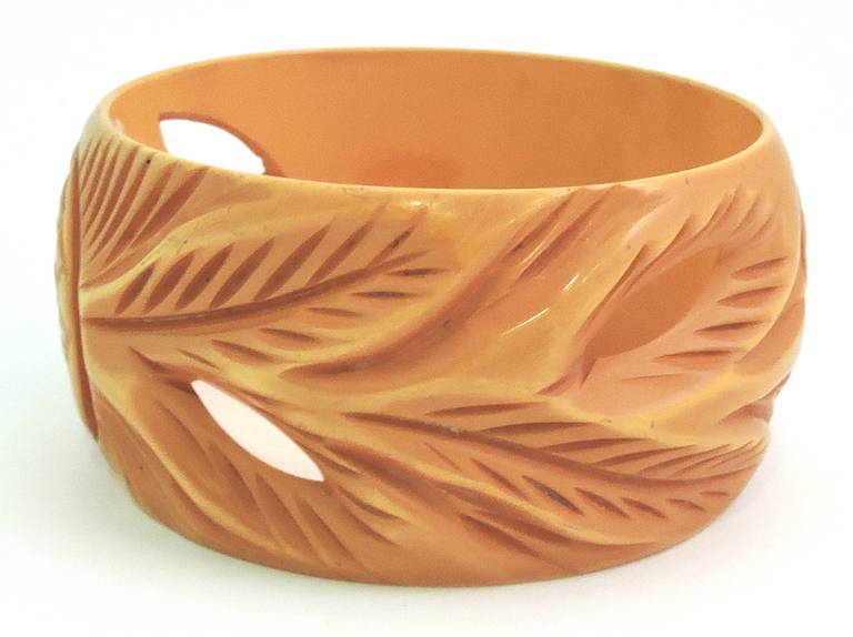 This vintage deco bangle bracelet features a heavily carved pineapple and leaf design in butterscotch Bakelite.  In excellent condition, this bangle measures 8” x 1 ½”.
