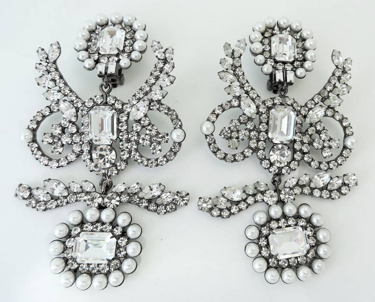 These signed Kenneth J. Lane earrings feature faux pearls with clear rhinestone accents in a silver-tone setting.  In excellent condition, these clip earrings measure 4 1/8” x 2 ½” and are signed “Kenneth Lane”.