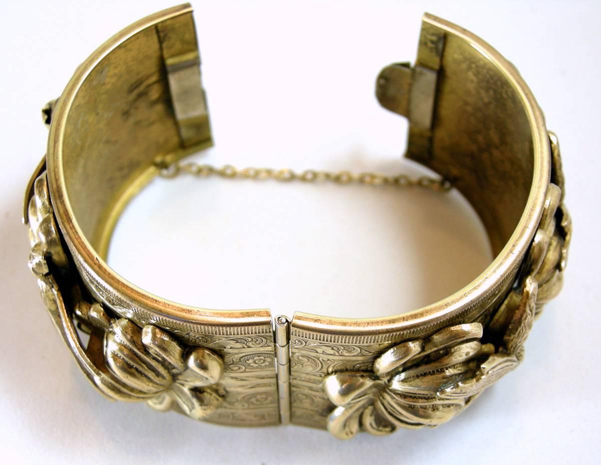 This unique vintage bracelet features a heavily carved design with bumble bees and flowers nestled in a gold-tone setting.  This bracelet measures 6-1/2” x 1-1/2” with a slide-in clasp and is in excellent condition.