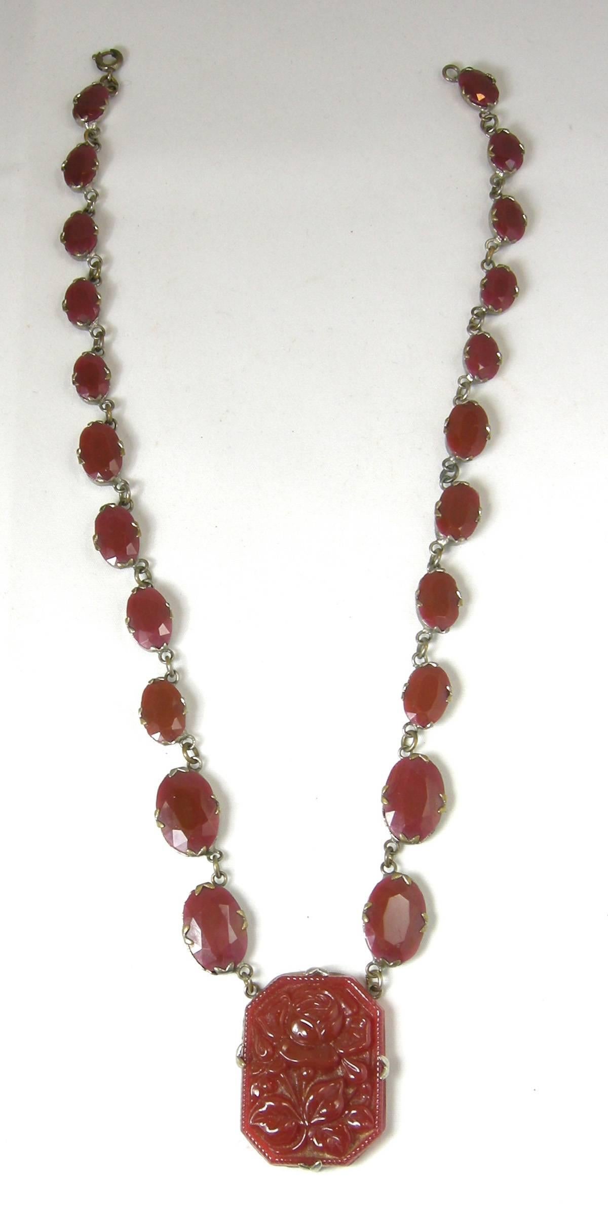 This vintage 1930s necklace features a heavily carved floral design in carnelian stone with faceted carnelians along the sterling silver chain.  This necklace measures 17” x 1/2” and the centerpiece is 1-1/4” x 1” and has a spring closure. This