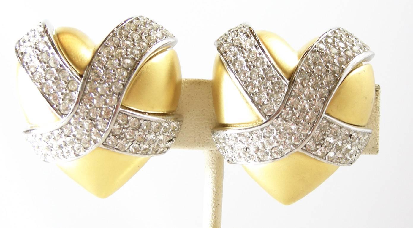 These vintage signed Givenchy earrings has a heart design with beautiful clear rhinestones in the center. It’s made in a matte gold-tone metal setting.  These clip earrings measure 1-1/4” x 1-1/4” and are signed “Givenchy”.  They are in excellent