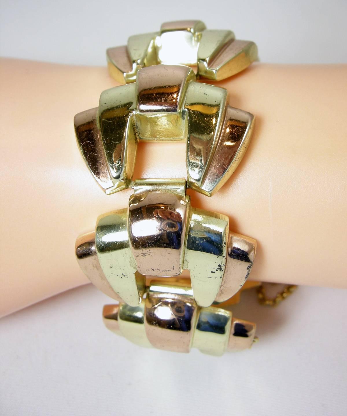 This vintage 1940s signed Monet bracelet features gold and white sterling silver in a large link design. It measures 7” x 1-1/4” with a slide-in clasp and a safety chain.  It is signed both “Monet” and “Sterling” and is in excellent condition. 

