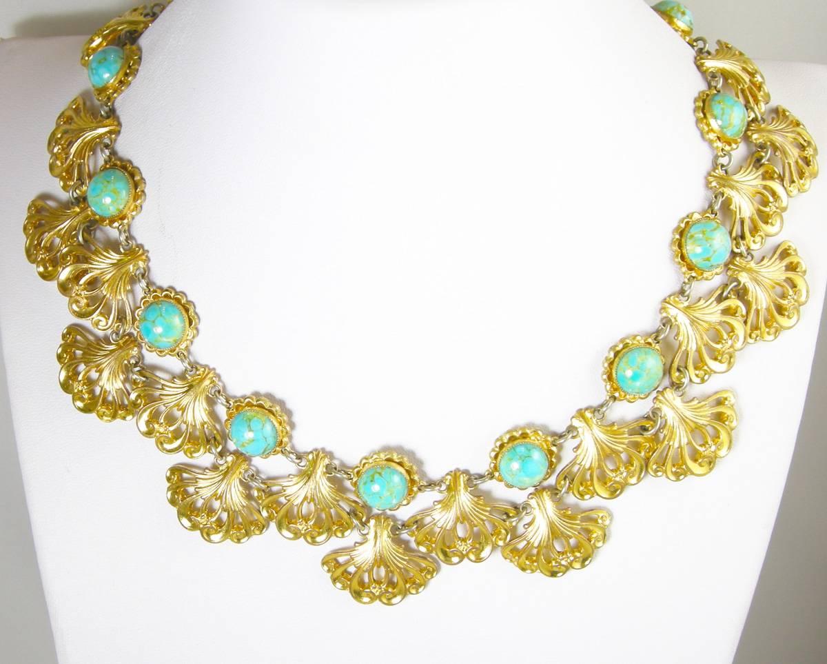 This vintage 1930’s necklace features alternating seashells with faux turquoise in a gold tone setting. This necklace sits comfortably, is well made and measures 17”.  The shells measure 1” each and has a slide in clasp and is in excellent condition.