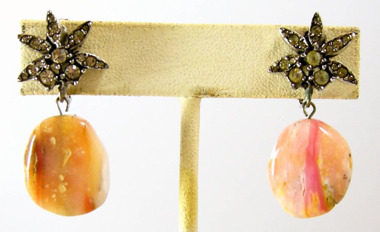 Ciner is a dependable jewelry company that creates splendid and well made jewelry. This subtle pair of earrings has rhinestones on top with a flat pink dangling stone that we assume is agate.These earrings are light, can be worn day or night and are