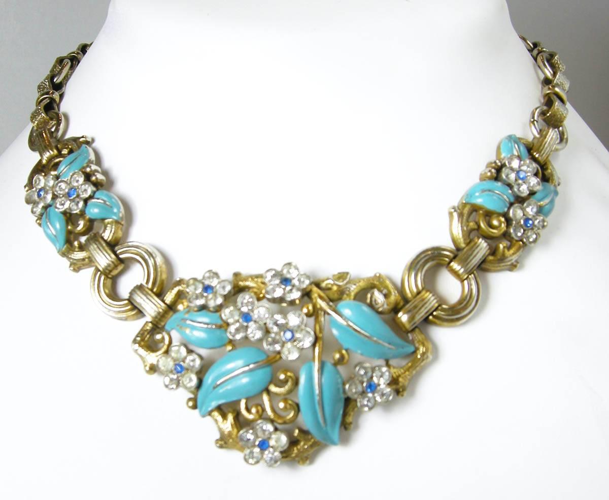 I was shocked to find this rare signed Trifari necklace!  This Art Deco piece features a floral design with blue enameling and clear rhinestone accents in a gold-tone setting.  The Trifari necklace measures 15  long with a fold-over clasp and the