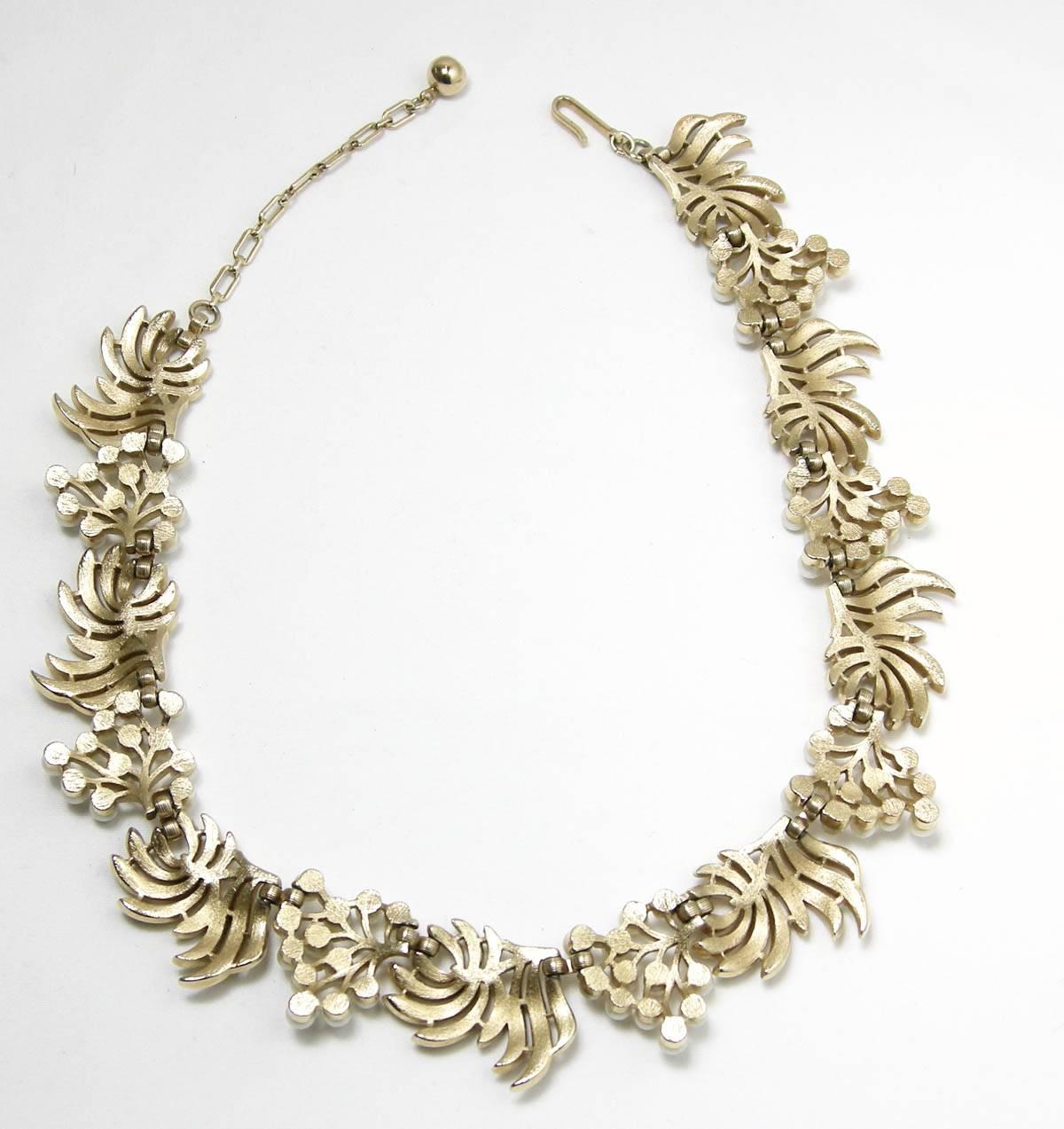 This famous vintage Trifari necklace was very popular in the 1950s and is considered a must-have for every important collection.  It features gold tone metal leaves that alternate with round faux pearls. It is signed “Trifari” and measures 16-1/2” x