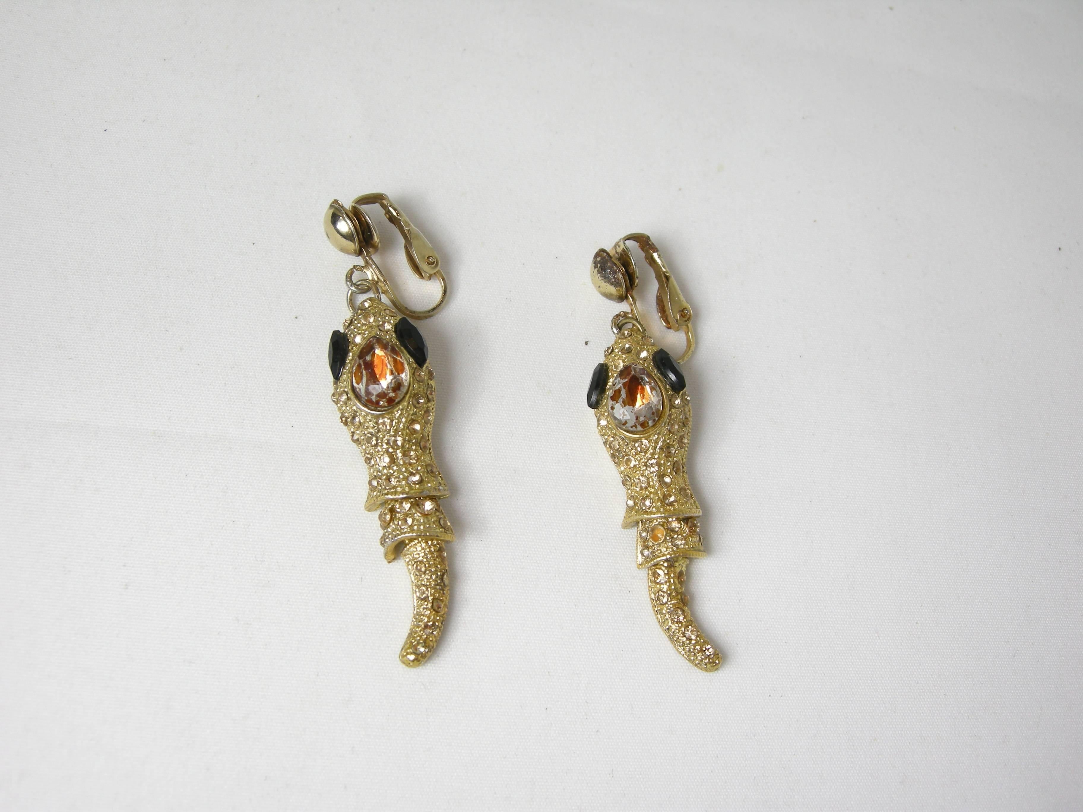 These 50s snake earrings Will charm you. They have brown crystals that look like chocolate diamonds and faux onyx for eyes. These clip ons measure 2¼”x ½” and have a gold tone setting. They are in excellent condition
