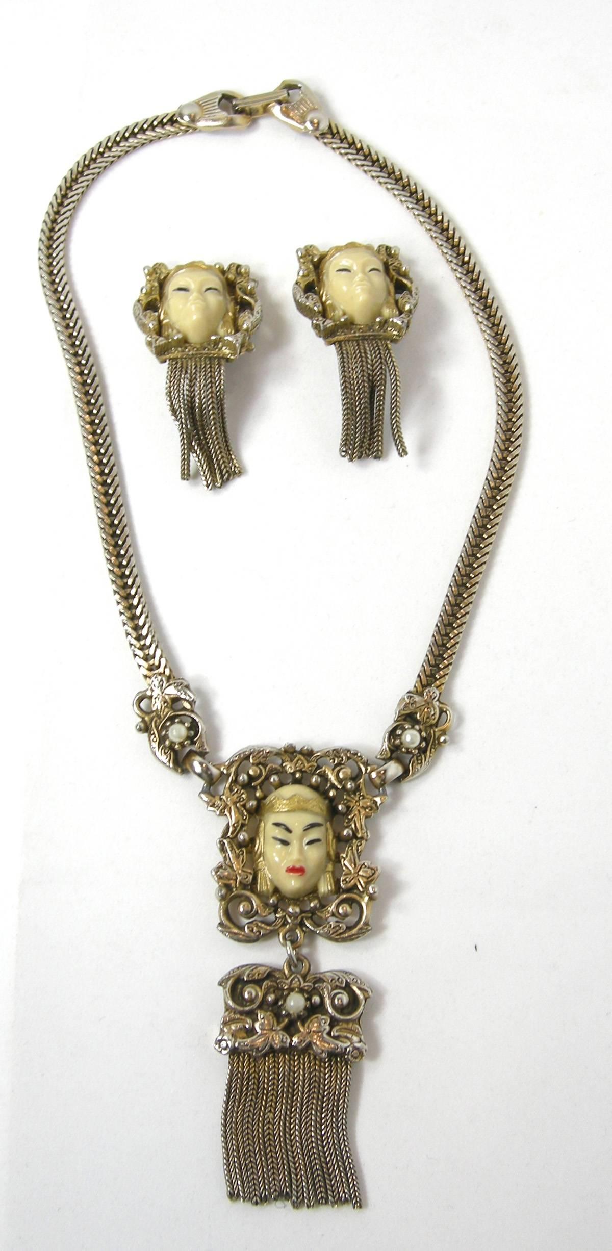 This is an exquisite intricate gold tone famous Selro princess necklace.  It is adorned with faux pearls, beautiful painted face, dangling chains with a safety sturdy closure.  The necklace measures 15