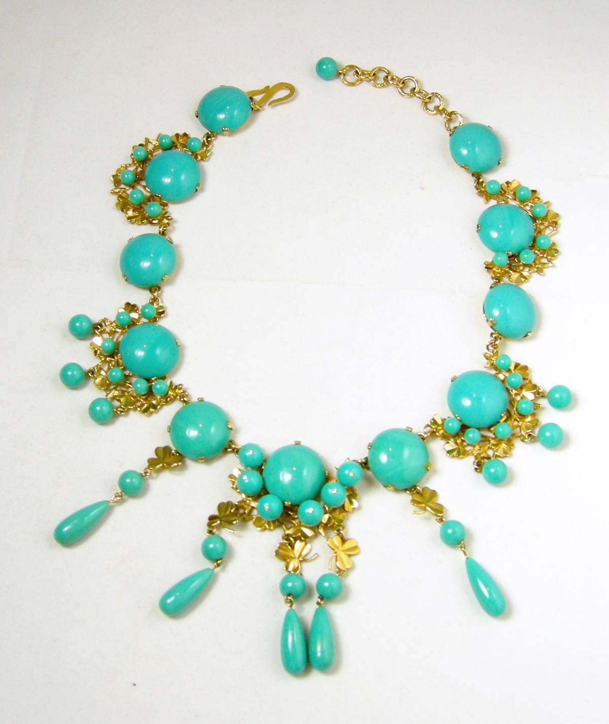 What a beautiful Christian Dior necklace designed with faux turquoise circles streaming downward.  The turquoise circles alternates with more circles surrounded with small turquoise glass beads resting on a gold tone decorative setting.  The design