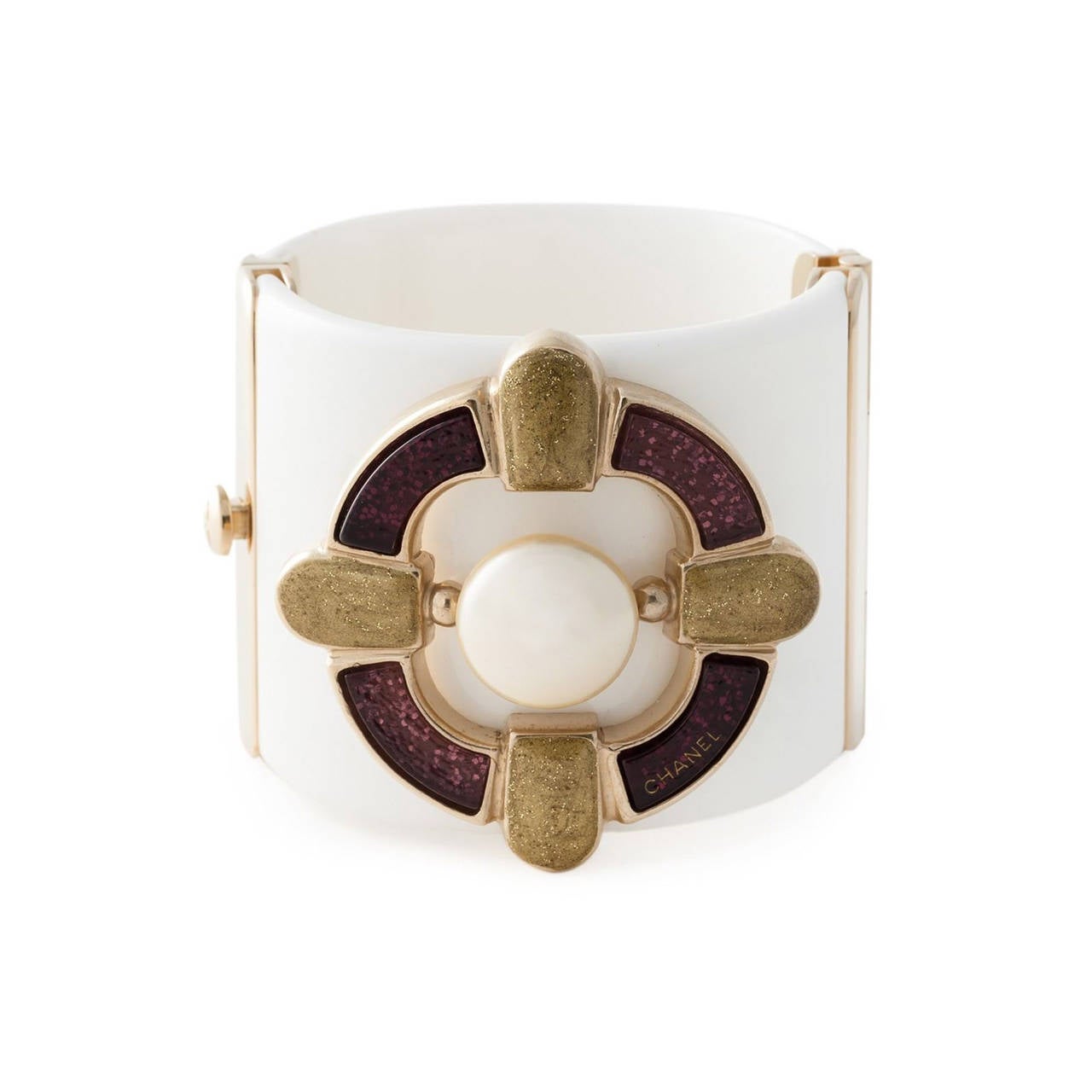 This show stopping Chanel bracelet cuff features a clasp fastening, a central faux-pearl, resin appliqués and gold-tone hardware.

Measurements: Circumference: 17.8 cm, Width: 5.2 cm

Material: Resin, Metal

Colour: Gold, White, Purple