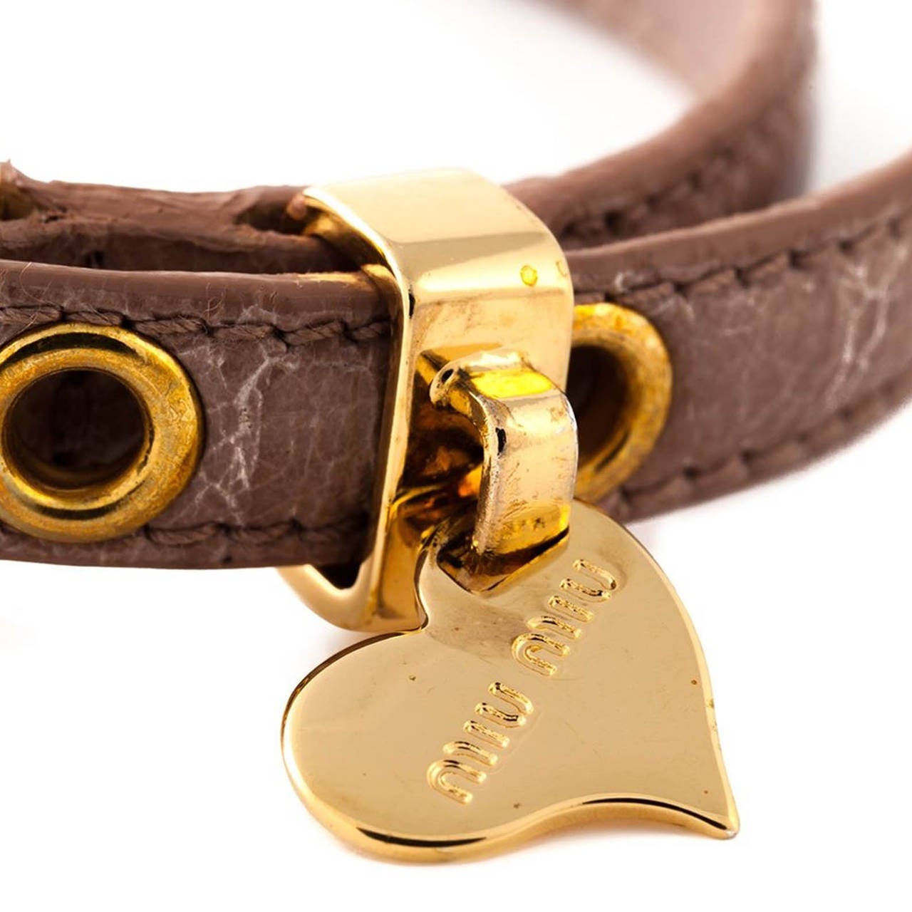 This Miu Miu bracelet features a gold-tone buckle fastening, gold-tone hardware and an embossed logo heart pendant and comes in Beige Leather.

Measurements: Circumference: 17 cm

Material: Leather

Colour: Beige