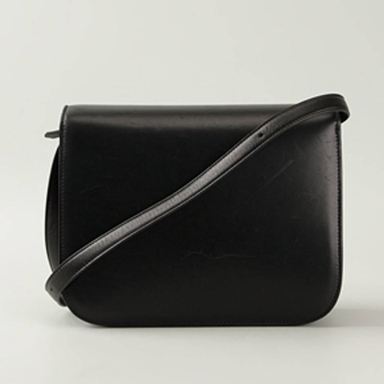 A complete classic that perfectly complements any look, this Black Leather 'Box' crossbody bag from Céline Vintage features a rounded shape, a foldover top with push-lock closure, a shoulder strap, a front embossed logo stamp, multiple interior