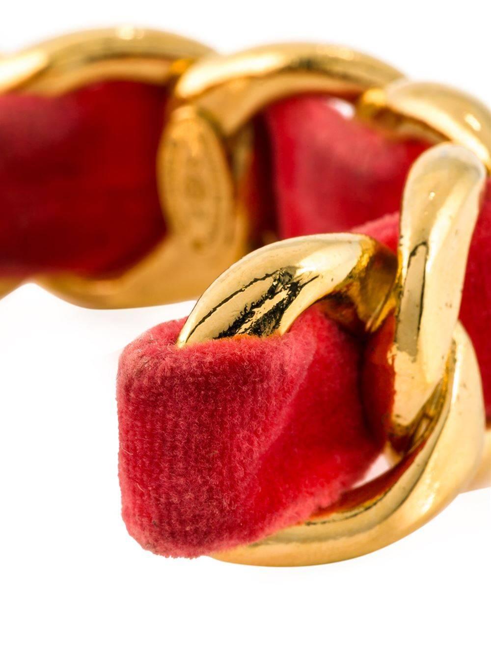 Gold-tone and red velvet curb chain cuff from Chanel Vintage.

Colour: Gold, red/ pink

Material: Metal, velvet

Measurements: width: 2.2 centimetres, circumference: 17.1 centimetres

Condition: Very good
The metal is in very good