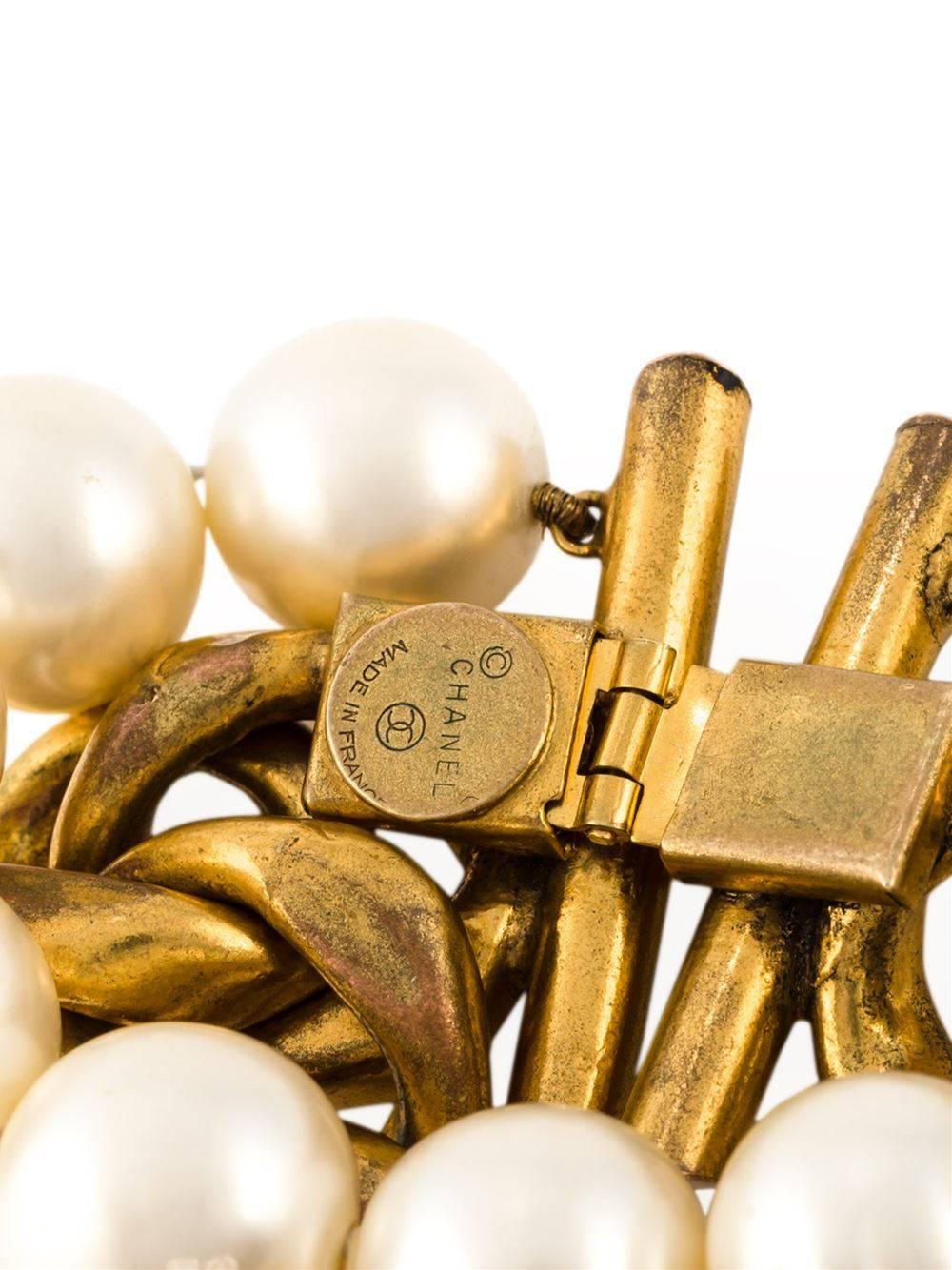 Gold-tone and white mother of pearl chain and pearls bracelet from Chanel Vintage. 

Colour: Gold, pearl

Material: gold- plated metal, faux pearl

Measurements: width: 3 centimetres, circumference: 16.5 centimetres

Condition: Very good