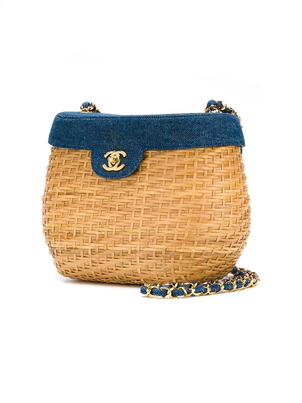 Denim and wicker basket crossbody bag from Chanel Vintage featuring a woven design, a gold-tone chain shoulder strap, a gold-tone logo plaque, foldover top with twist-lock closure, an internal zipped pocket and an internal logo stamp. 

Colour: