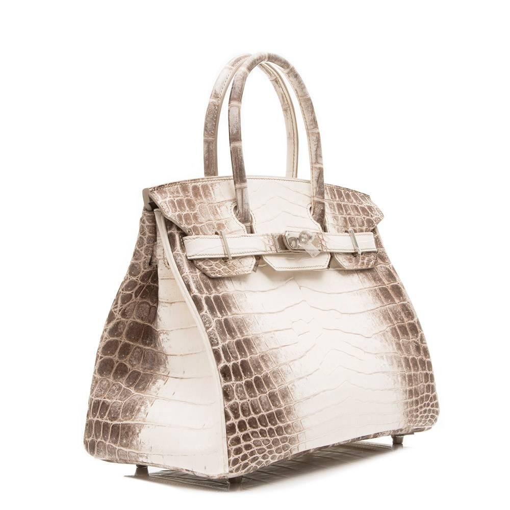 The most sought after of all the Hermes bags, this beautifully crafted, rare Birkin is made from matte Niloticus crocodile leather and features palladium hardware.

Lined with grey goat skin leather the bag's interior boasts one zipped and one