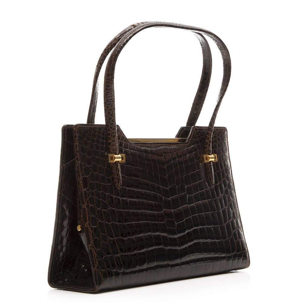 Gucci vintage handbag in brown crocodile leather with gold - plated hardware. 

The bag has three compartments with the main, middle compartment featuring snap lock closure, a zipped pock and two open pockets.

Colour: brown

Material: