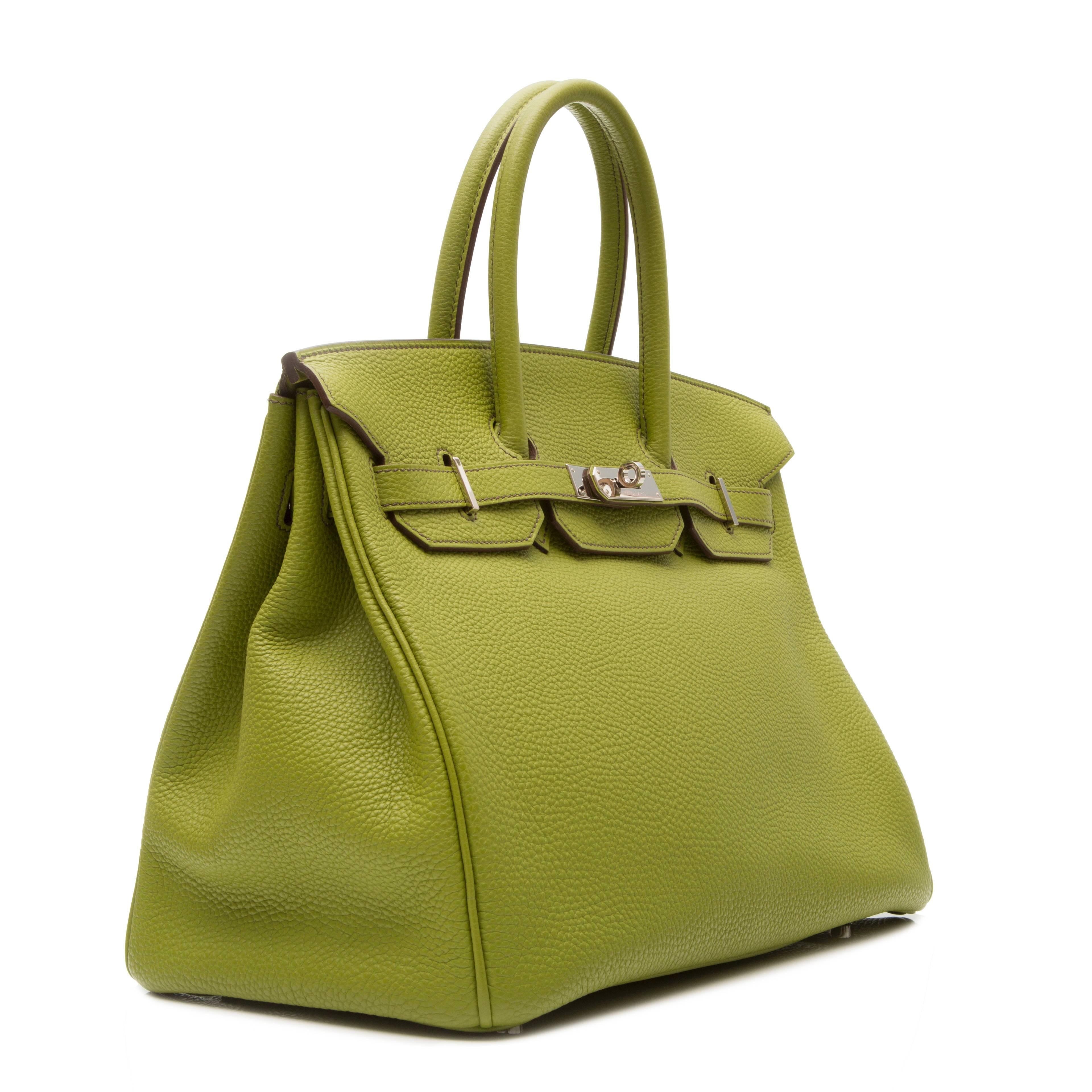 Green leather 'Birkin' tote featuring a trapeze body, round top handles, foldover top with twist-lock closure, a pebbled leather texture, silver-tone hardware, a padlock fastening detail, a hanging key fob, an internal zipped pocket and purse feet.