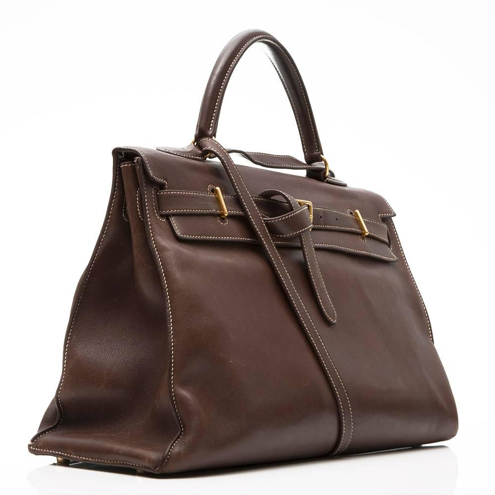 Hermes Kelly flat in chocolate brown Swift leather featuring gold- plated hardware. This bag is made so that it can be folded up and worn as a clutch. The interior of the bag has three open pockets.

Colour: Chocolate Brown

Material: Swift
