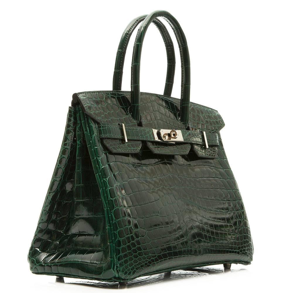 Hermes Birkin Bag in dark green Niloticus crocodile leather with Palladium hardware. The interior is lined in dark green goatskin and boasts one zipped and one open pocket.

This bag comes with its original lock and key, care booklet, raincoat and