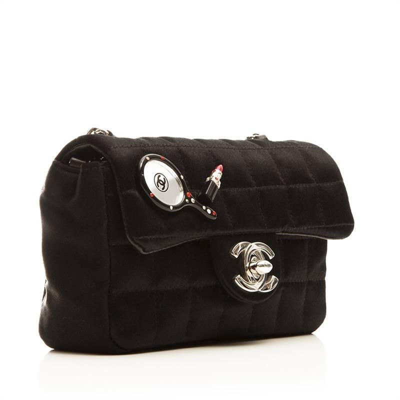 This rare mini shoulder bag features a sateen body, leather trim on the interior, silver-tone hardware along the chain and clasp and a playful tennis and lipstick mirror detail on the face. 

Colour: Black

Material: Sateen

Measurements: