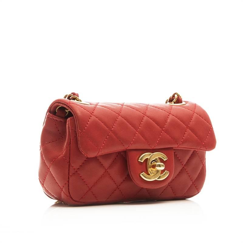 Chanel quilted red lambskin mini flap bag featuring gold tone hardware and perspex and wooden charms. The lining of the bag is cream canvas with one open pocket.

Colour: Red

Material: Lambskin Leather

Measurements: W: 14cm H: 8cm D: