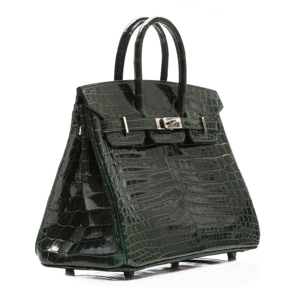 Hermes Birkin Bag in dark green Niloticus crocodile leather with Palladium hardware. The interior is lined in dark green goatskin and boasts one zipped and one open pocket.

This bag comes with its original lock and key and dustbag

Colour: Dark