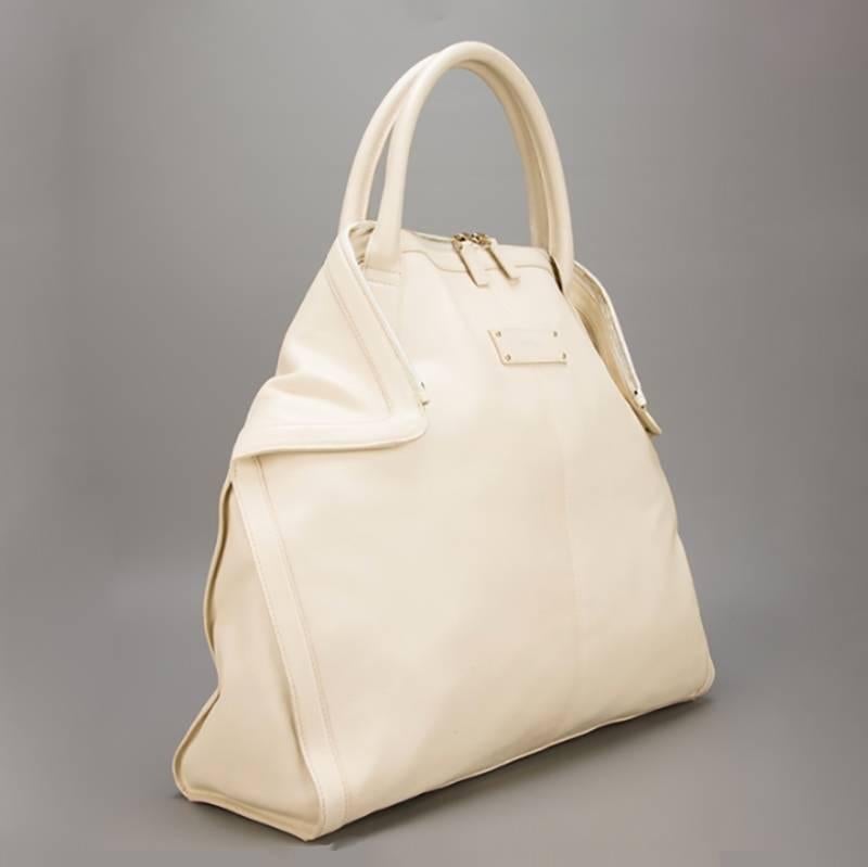 Strikingly understated in its design, this large Alexander McQueen De Manta tote features a minimalist, cream facade, quietly accented by an Alexander McQueen logo stamp. It is discretely finished with gold-tone hardware. An incredibly spacious