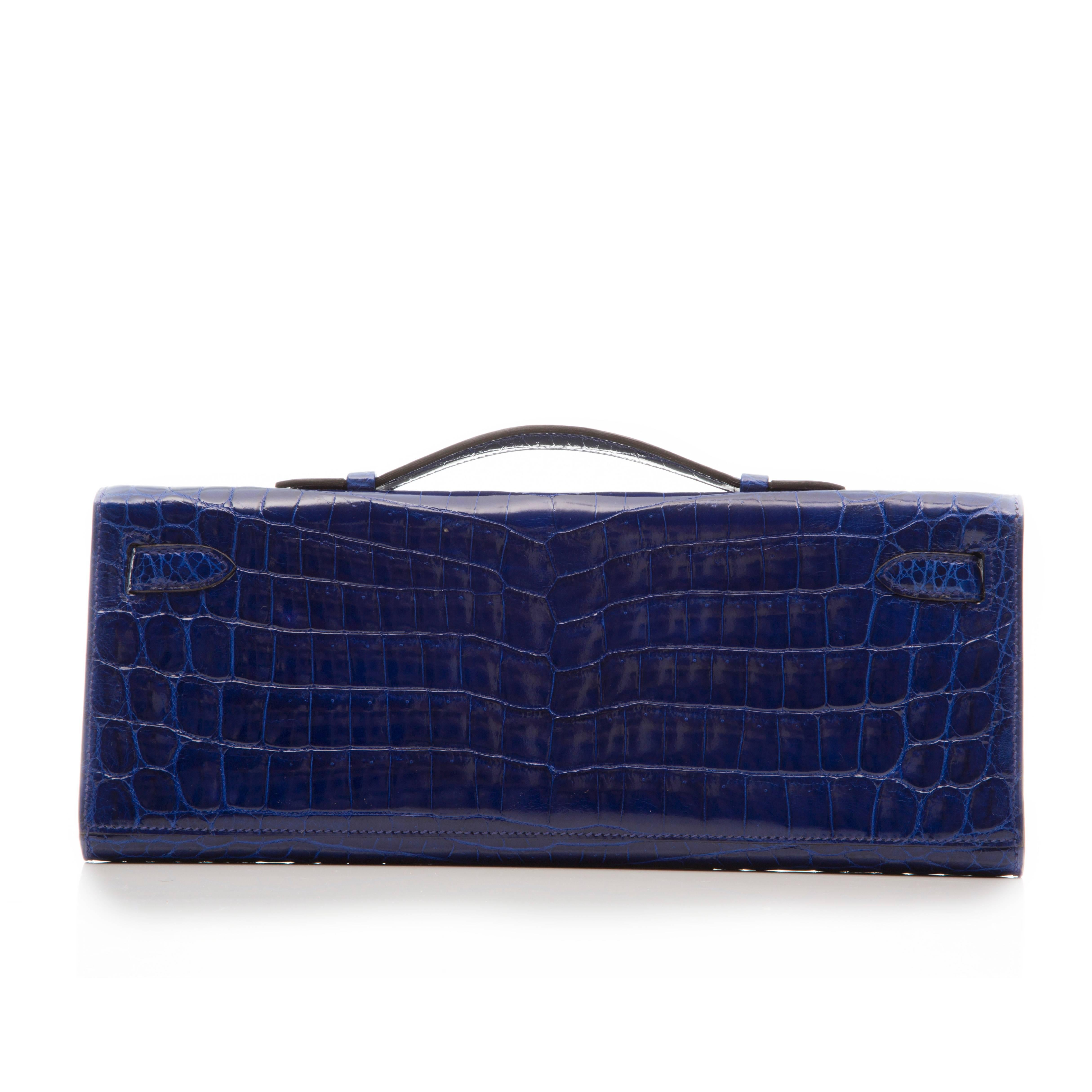 Crafted in Shiny Niloticus Crocodile with silver palladium hardware, this Electric Blue Kelly Cut clutch by Hermes features tonal stitching, front straps with toggle closure and a top flat handle. The interior is lined in matching Electric Blue