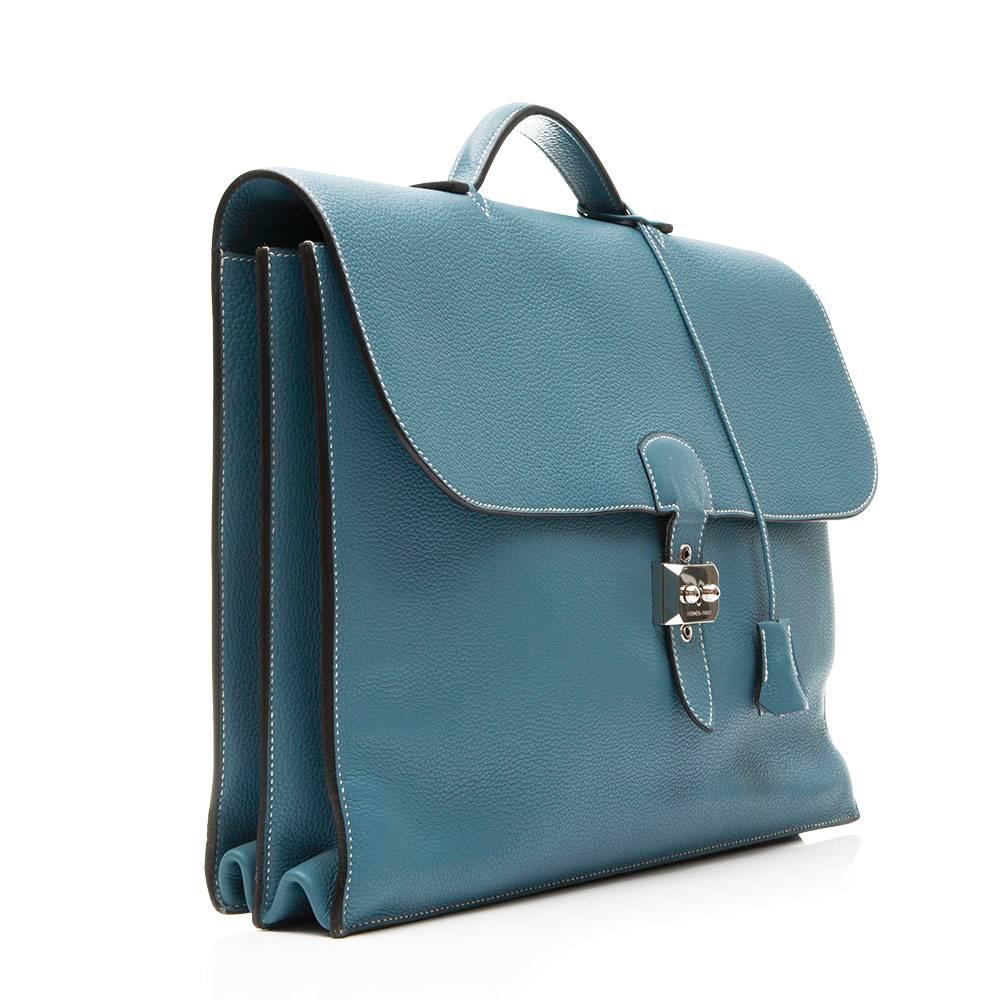 Vitalise your office repertoire with a spectacularly coloured briefcase from Hermès. In the deep, oceanic shade of Bl​ue Jean ​offset with palladium hardware, this Sac a Depeche is outfitted with a top handle, a belt-like clasp, and three spacious