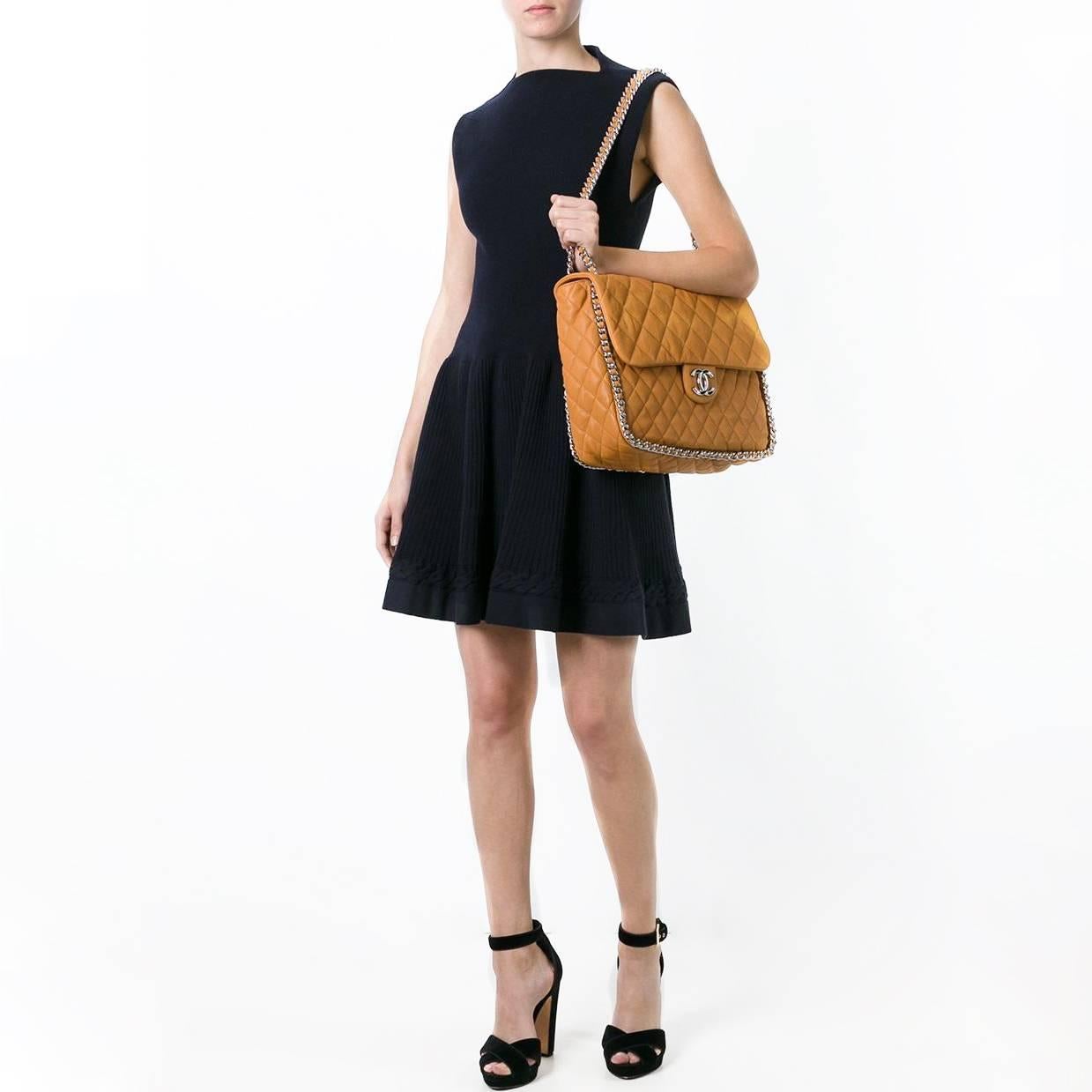 Make a big statement with a jumbo-sized Chanel Flap bag. This rare spin on a Chanel classic features a “chain around” design, in which Chanel's iconic woven strap is found wrapped along the edges of the bag. Its quilted leather facade is coloured in