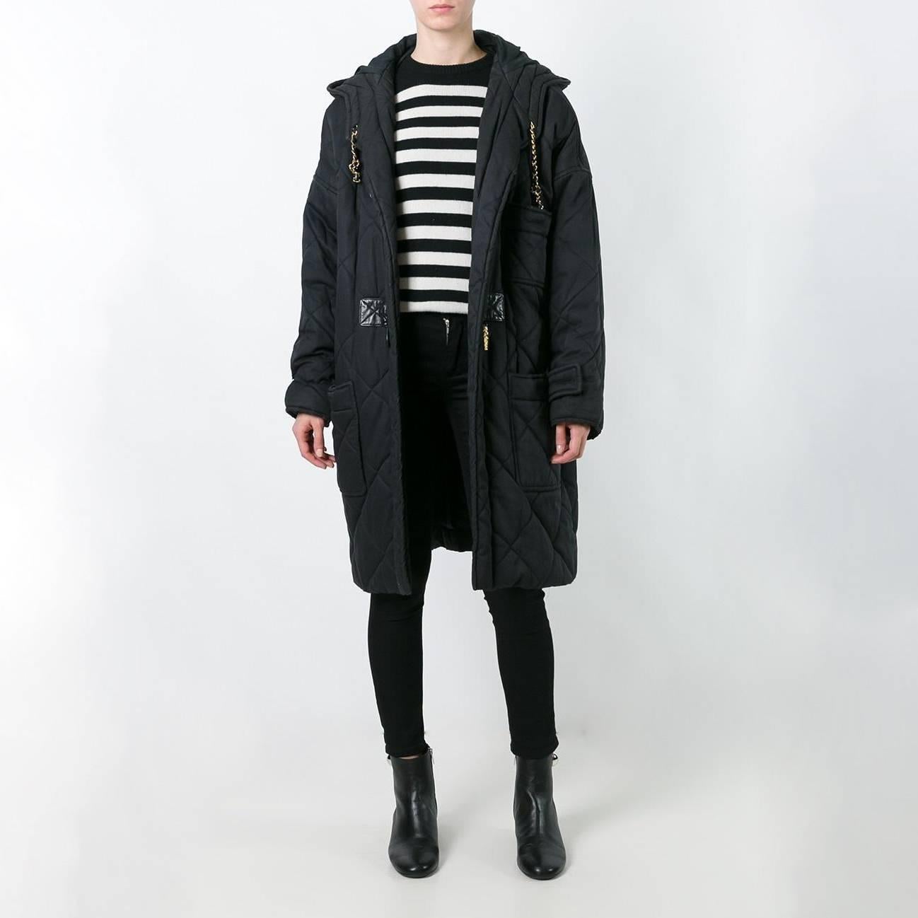 Stay warm in style with this vintage Chanel duffle coat. A classic black, padded gabardine coat is elevated with the brand’s signature codes, including an all-over quilting, a woven chain drawstring around the hood, and embossed gold-tone toggles