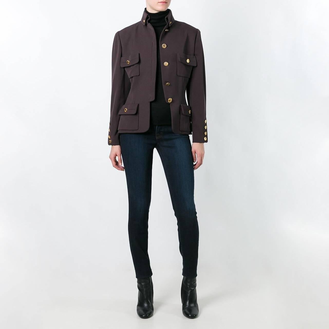 Ornately embellished with gold-tone medallions, this vintage Chanel jacket is crafted from a brown wool gabardine. It was designed in 1985-86, at which point Karl Lagerfeld had only recently been inducted to the role of creative director. In a