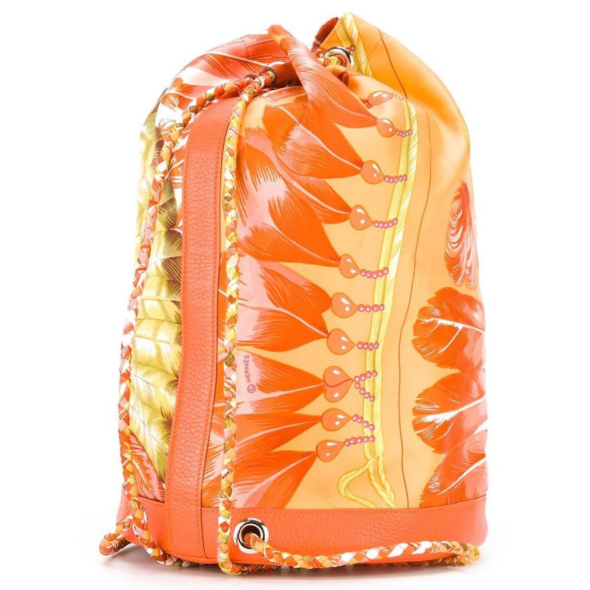 Exude tropical fantasies with this vintage Hermès backpack. A sun-soaked pattern in shades of orange and green features across the bag's drawstring profile. It is printed with the word Brazil, and the Hermès logo. The backpack straps are woven,