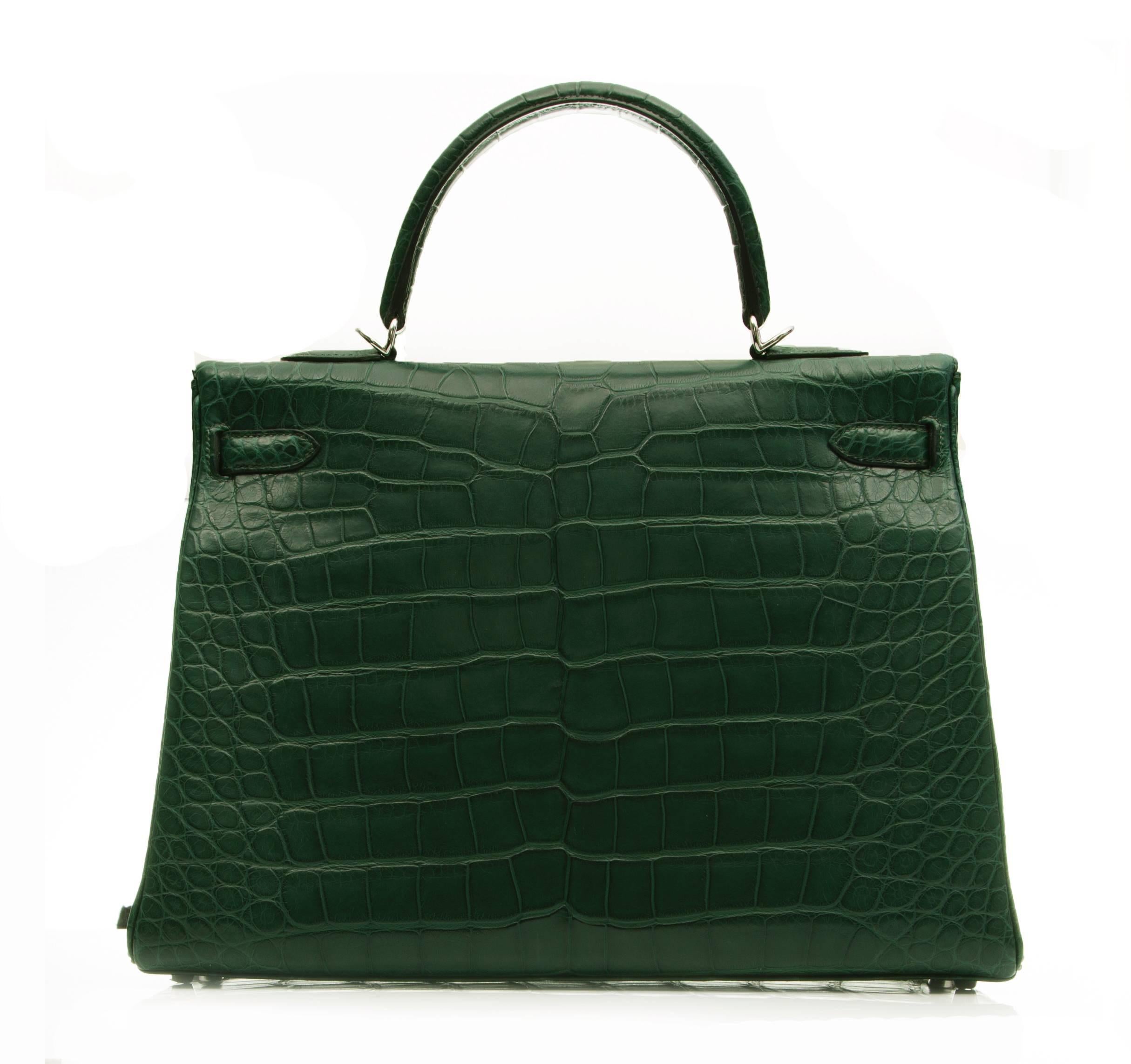 The ultimate ladylike companion, this edition of the Hermès Kelly handbag is crafted in matte alligator leather. In Hermès' dark green shade of Vert Foncé, the tote bag is offset with palladium hardware. The spacious interior of the Kelly 35