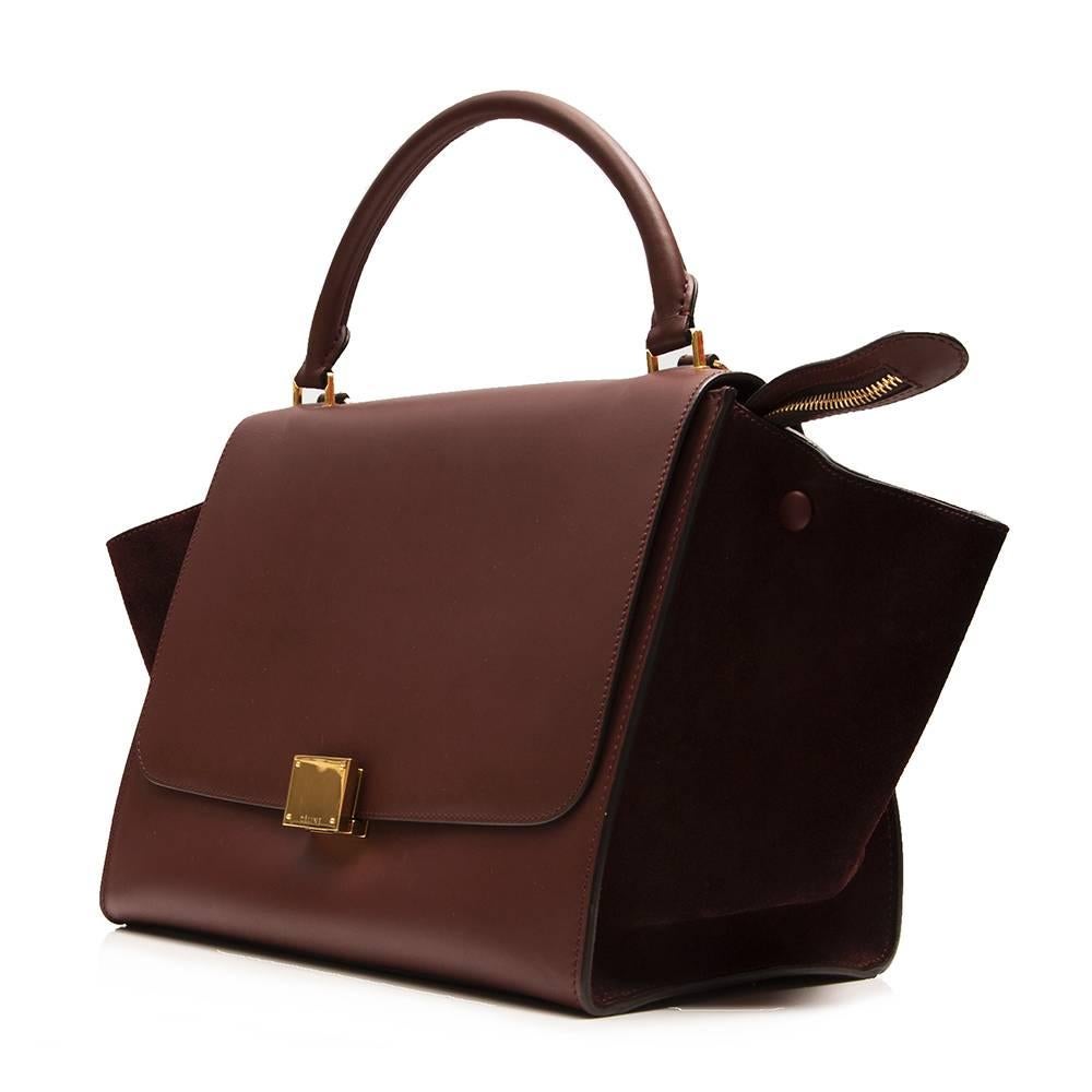 Exuding the sleek modernity of the brand, this Céline Trapeze handbag is crafted from a smooth brown leather offset with tonal suede panels. Its practical design includes a removable shoulder strap, collapsible sides, a rear zipper pocket and two