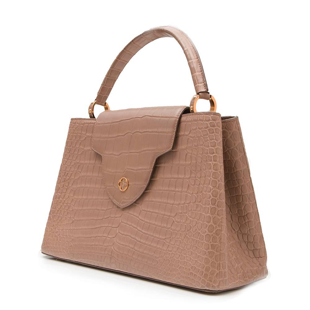 Utterly feminine in the most classic fashion, this Louis Vuitton Capucines tote bag features a structured silhouette finished with a top handle. It is rendered in a beige crocodile skin, offset with gold-plated hardware, including a quatrefoil at