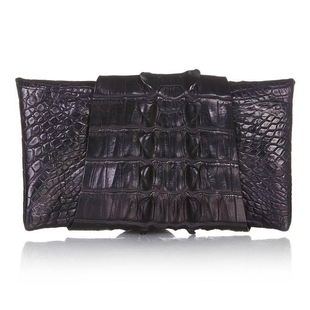 Balmain is the ultimate brand for high-octane statement pieces. This darkly glamorous Balmain clutch is crafted from black crocodile skin. Note the back horns that feature as decorative spike details. The unusual design features a long panel of