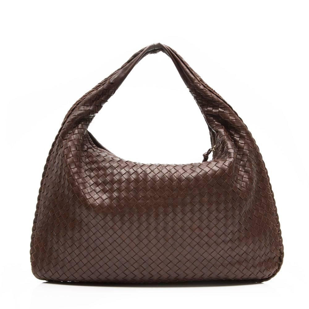 This Bottega Veneta handbag is beautifully crafted in a soft, brown leather, transformed through the brand's signature Intrecciato weaving technique. Its gold-tone zipper is finished with a leather knot – another house code – and opens to reveal a
