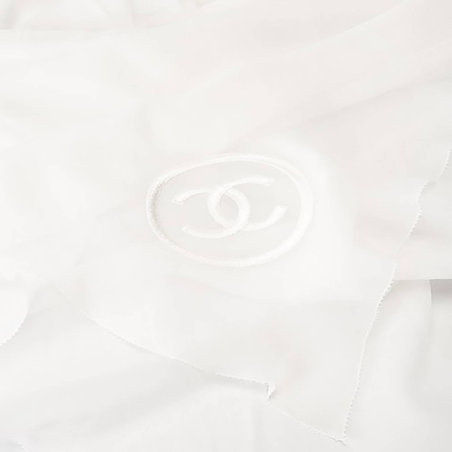 Utterly feminine, this Chanel scarf is rendered in a floaty, ivory silk. Its pleated silhouette tapers at the middle for a flattering effect when wrapped around the neck. The scarf features an embroidered Chanel monogram in tonal ivory