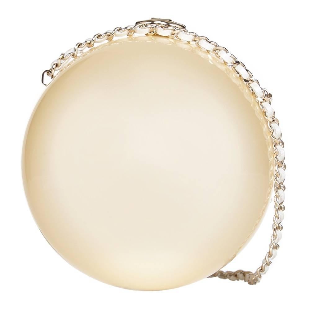 When we think of Chanel, we instantly think of fantasy pearls. This vintage minaudiere is crafted from lustrous ivory plexiglass and shaped like a ball. It opens with a pale gold-tone 'CC' clasp and has an ivory leather-woven chain shoulder strap