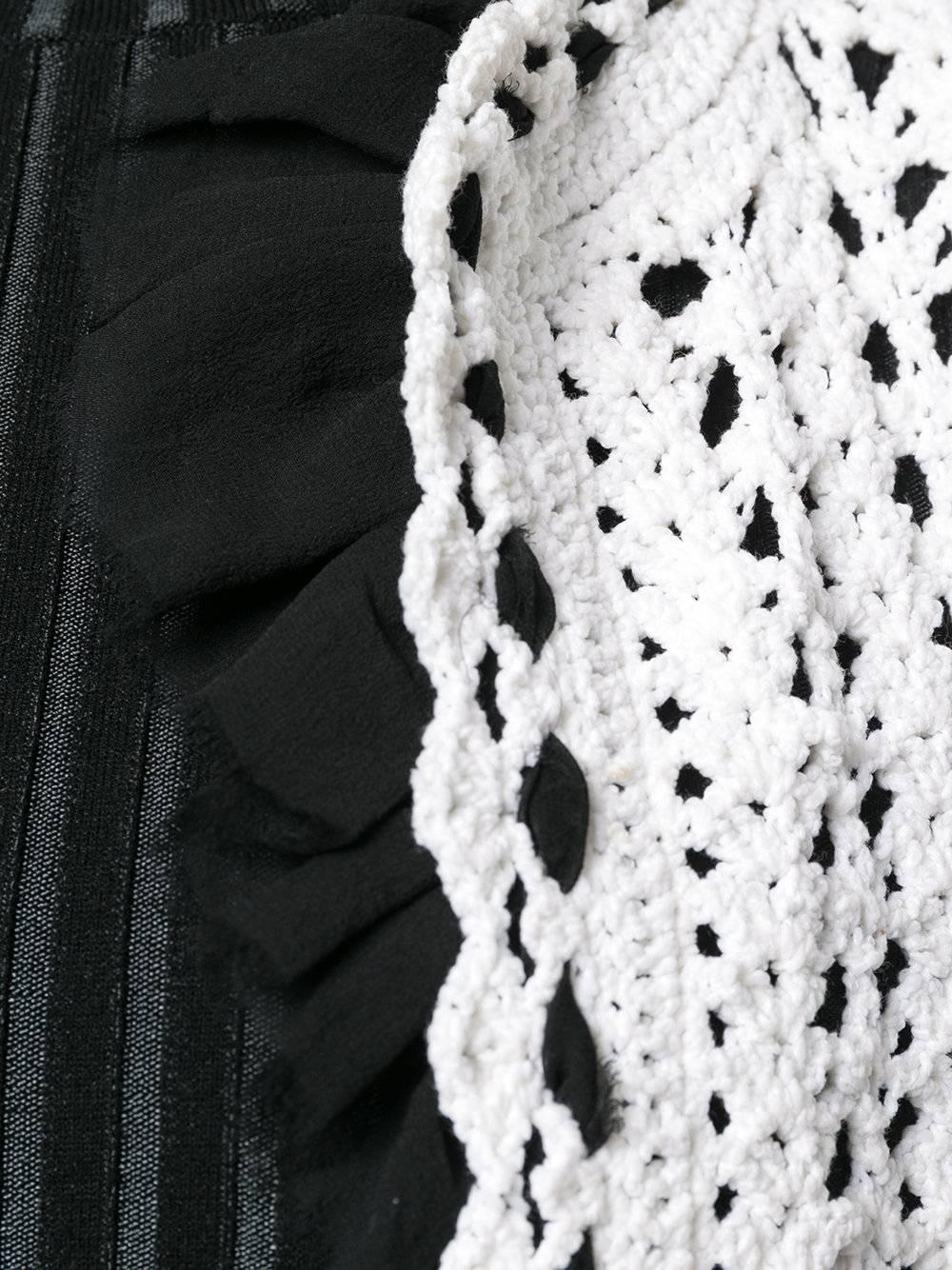 This vintage Chanel cardigan elevates the humble crochet with its black silk-chiffon ruffles. They're braided into the edges its open body, its pockets and cuffs. A long, relaxed silhouette and its openwork crochet make it perfect for layering.