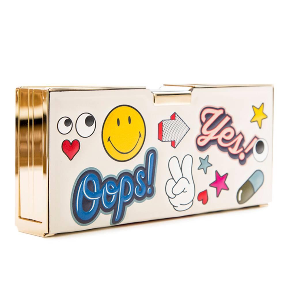 Go back to your school days with this playful Anya Hindmarch clutch bag! Based on the idea of a pencil case, the bag is covered in funky stickers, doodles and graphics. The brightly coloured stickers are embossed onto the chalk coloured leather,