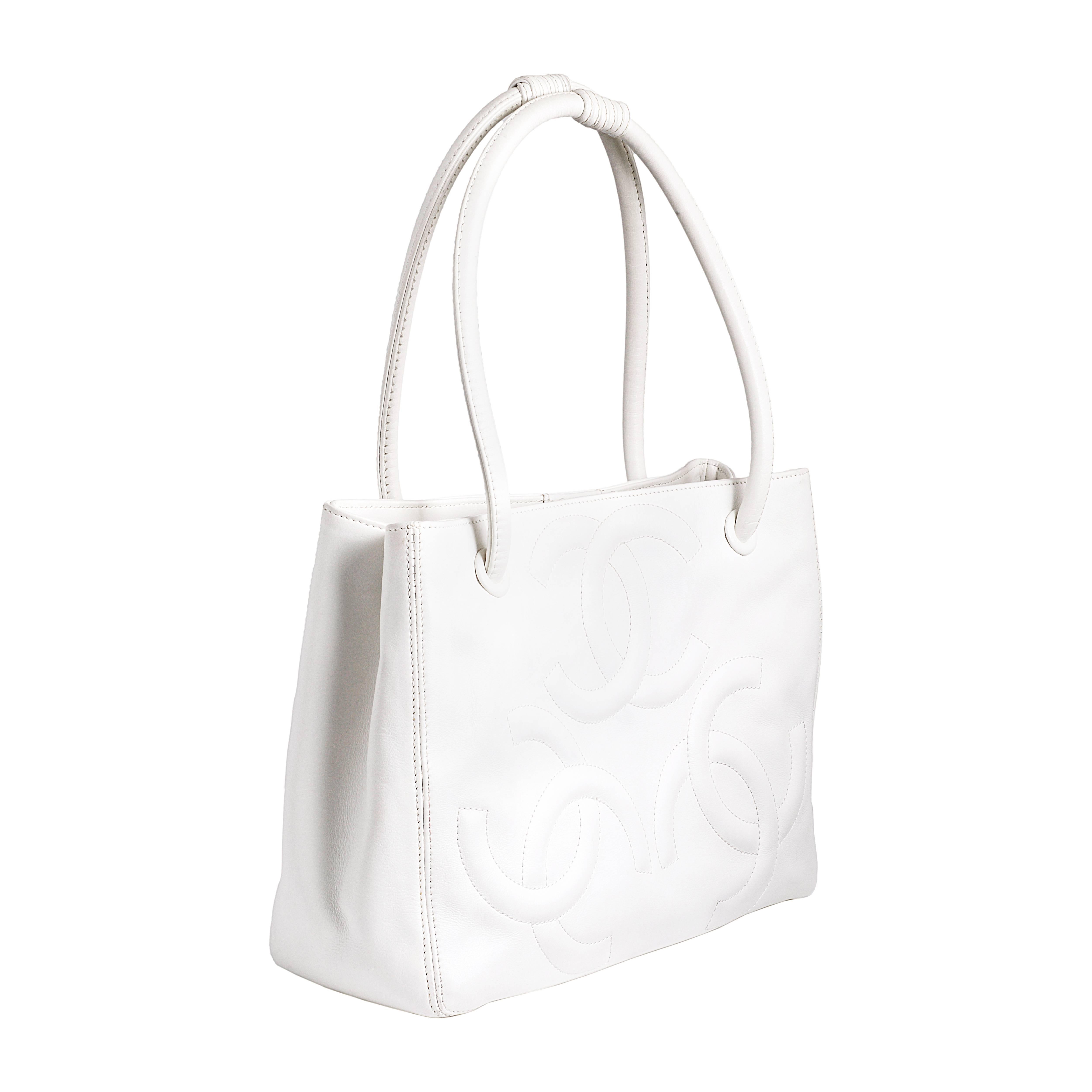 This vintage Chanel bag is simple yet chic. Featuring three large interlocking 'CC" logos this bag is crafted from beautiful white leather. The large internal compartment makes this the perfect everyday bag. The canvas interior features an