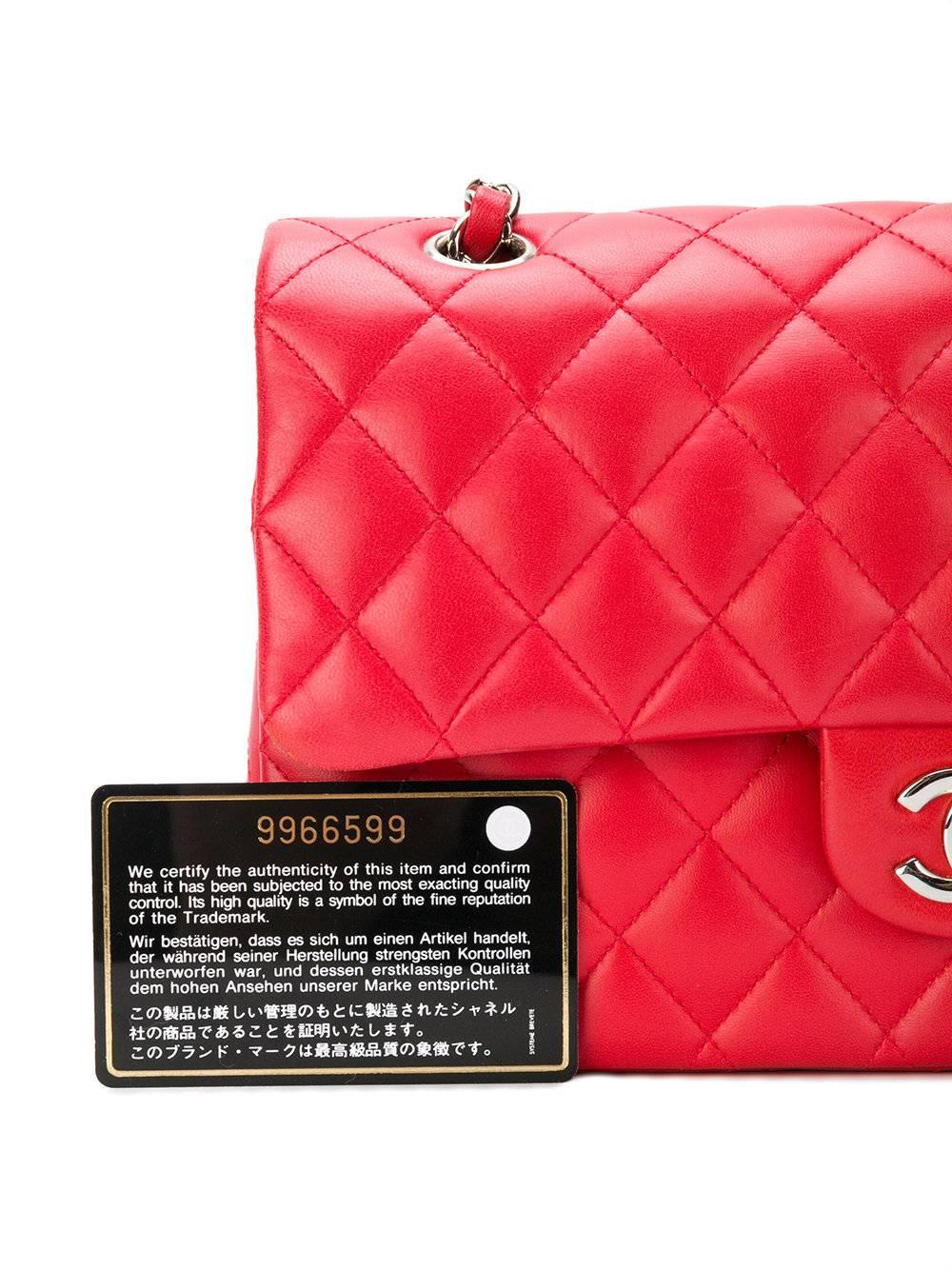 This iconic Chanel double flap shoulder bag was fashioned from smooth red lambskin, finished with a diamond quilt detail, one of the most iconic trademarks of the Maison. It features a leather shoulder strap, adorned with a silver-tone chain, and