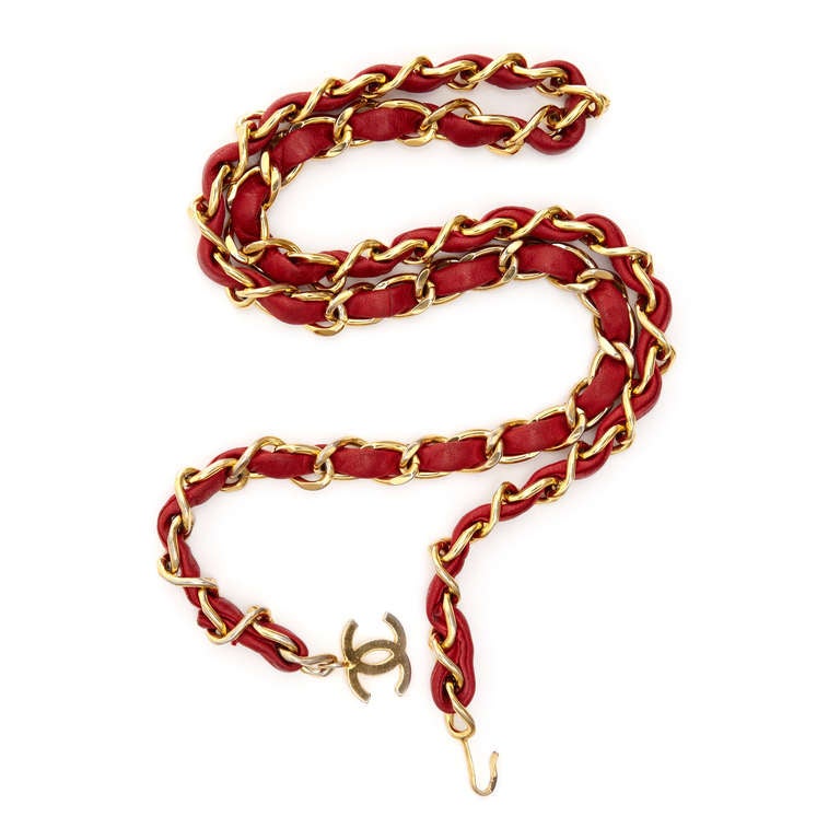 Gold-tone chain with woven red leather belt by Chanel Vintage featuring a signature CC logo hook closure.